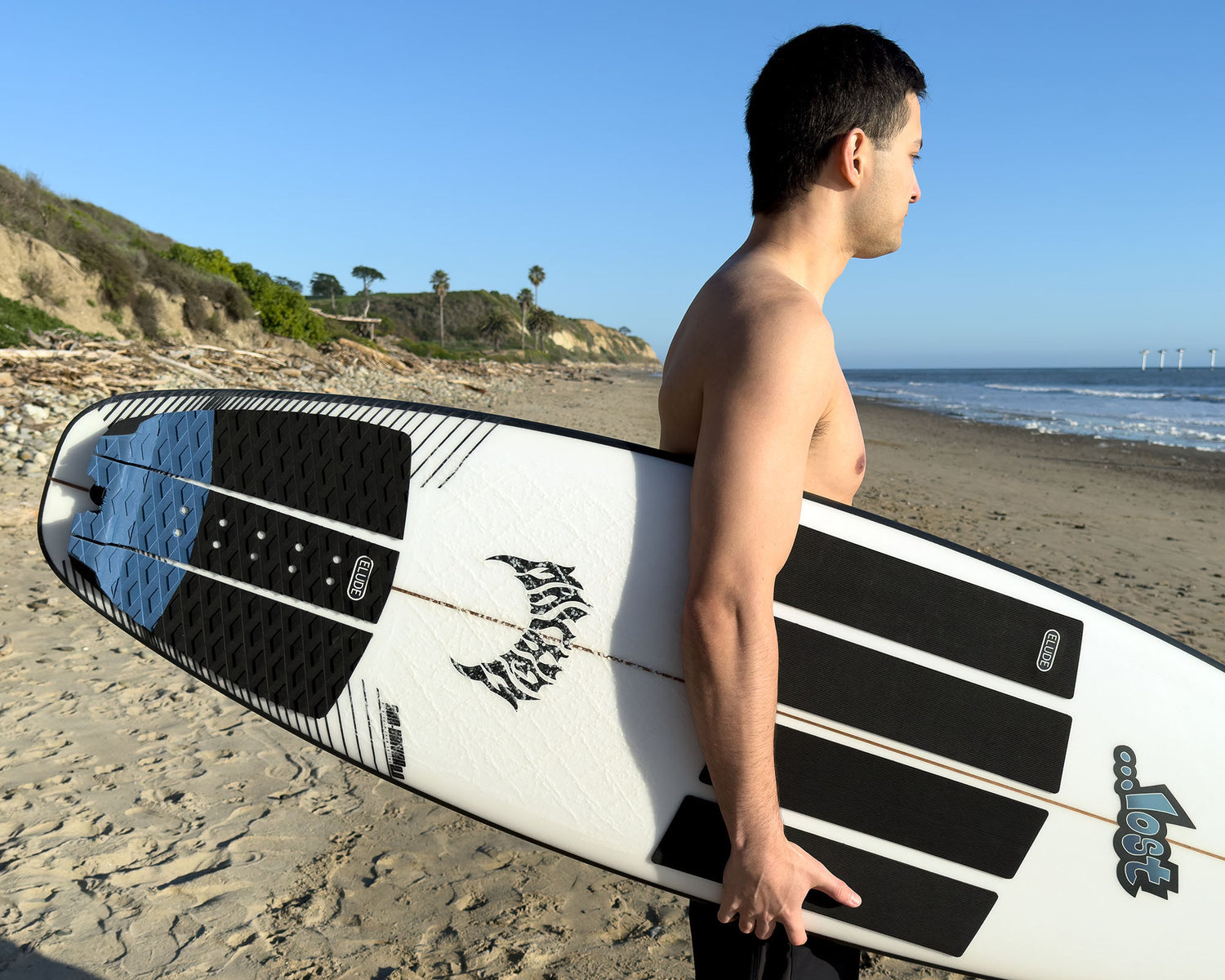 Surfer holding board with black front traction pads