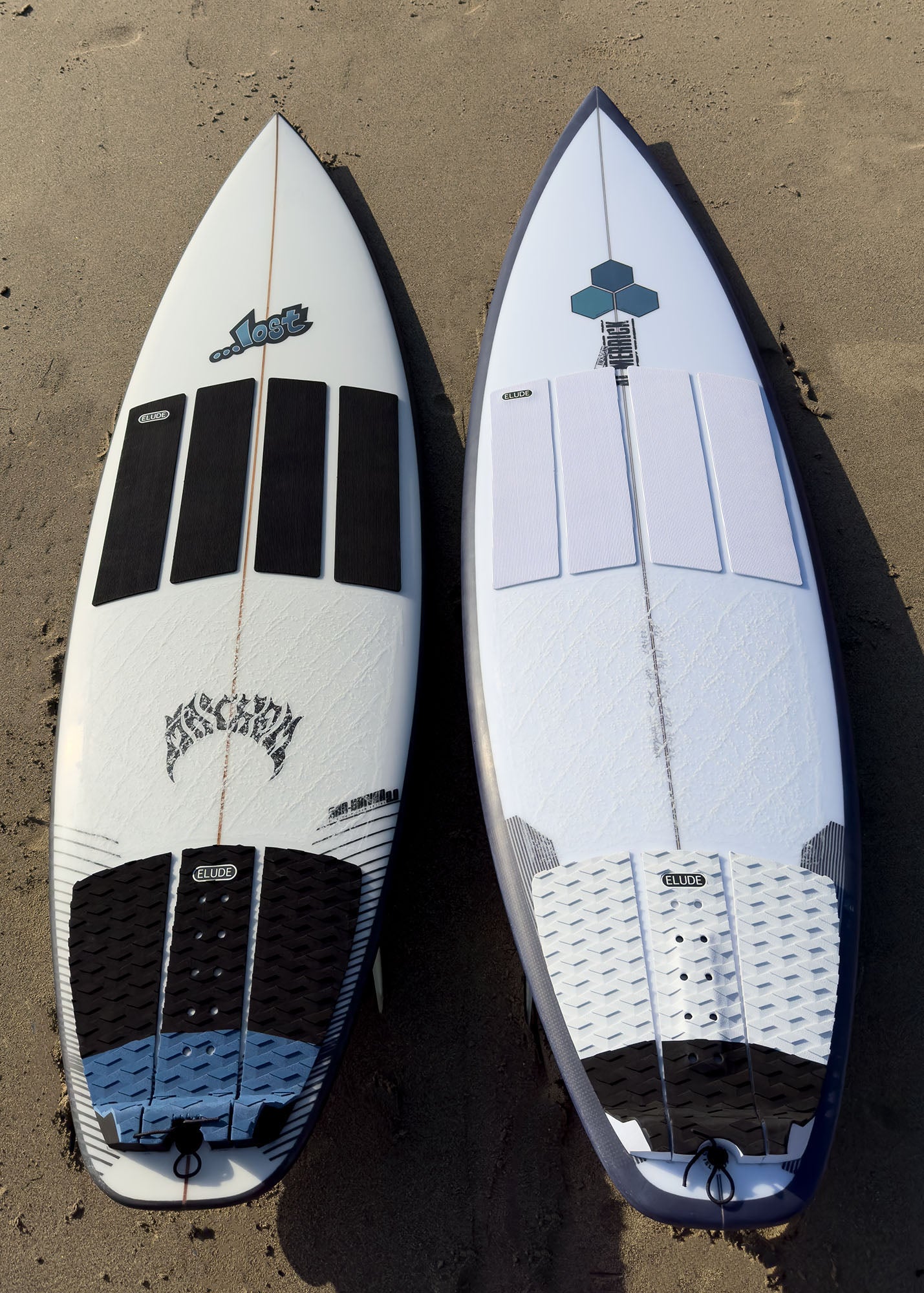 Two surfboards with white and black front and rear traction pads 